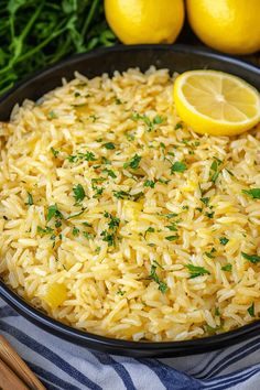 a pan filled with rice, lemons and parsley