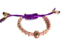 Beaded macrame bracelet with adjustable clasp. This is a stackable bracelet, you can wear it with other type of bracelets, the more the merrier, it will give that boho-chic style, with a sliding clasp. This beauty was made using the macramé technique. It was made with purple nylon cord and pink/salmon S-Lon cord, using the flat knot with golden tone (6/0) metal beads incorporated to the sides of the wrap; the focal point is a golden tone metallic bead. The result is an elegant, one-of a kind bra Beaded Macrame Bracelet, Lily Bracelet, Beaded Macrame, The More The Merrier, Handmade Beauty Products, Macrame Bracelet, Handmade Macrame, Stackable Bracelets, Macrame Bracelets