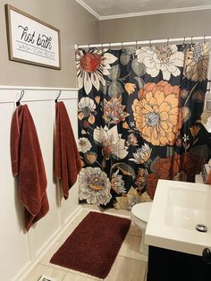 a bathroom with two towels hanging on the wall next to a sink and shower curtain