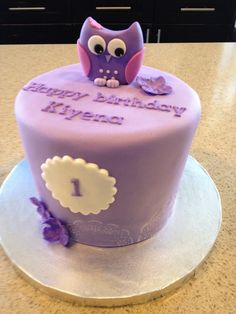 a purple cake with an owl on top