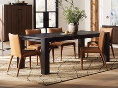 a dining room table with chairs and a potted plant on top of the table