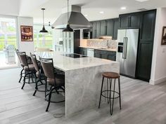 a large kitchen with an island and bar stools