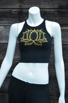 Gold Lotus Flower Fitted Crop Top - Women's Yoga Top - Festival Clothing This comfortable black fitted crop top features a double sided lotus flower design. The front has a large print in shinny metallic gold, and the back has a column of three smaller lotus flowers printed in glow in the dark. This Lotus flower is an original hand drawn image. The dark image shows the tank under a blacklight that is charging the glow in the dark ink.95% Cotton / 5% SpandexMade in the USAAvailable in sizes:SMALL Spring Fitted Yoga Tops, Fitted Crop Tank Top For Yoga, Black Cropped Crop Top For Yoga, Fitted Cropped Top For Yoga, Cotton Cropped Top For Yoga, Spring Cotton Crop Top For Yoga, Stretch Crop Top For Festivals, Fitted Cotton Tank Top For Festival, Fitted Cotton Tank Top For Festivals