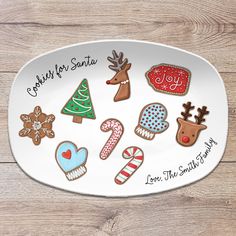 a white plate topped with lots of different decorated christmas cookies on top of a wooden table