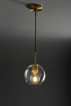 a light that is hanging from the ceiling in a room with dark walls and flooring