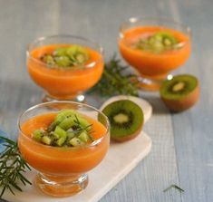 three glasses filled with orange and kiwi fruit