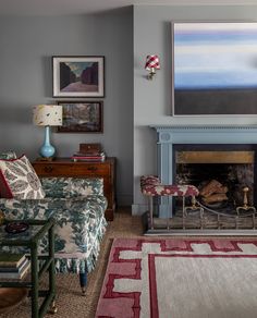 a living room filled with furniture and a fire place under a painting on the wall