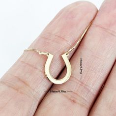 This stunning horseshoe gold necklace is a perfect symbol of good luck and charm. The pendant is crafted from high-quality 14k gold and features a beautifully designed horseshoe with intricate detailing that catches the eye. The pendant hangs on a dainty yet sturdy gold chain that complements the pendant's design, creating an elegant and timeless piece of jewelry. This necklace is perfect for adding a touch of equestrian style to any outfit, and is a must-have for any horse lover, cowgirl, or co Horseshoe Necklace Gold, Cowgirl Necklaces, Western Necklace, Jewelry Western, Lucky Charm Necklace, Western Necklaces, Horseshoe Necklace, Equestrian Jewelry, Cow Boy