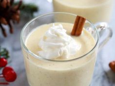 two glasses filled with whipped cream and cinnamon sticks