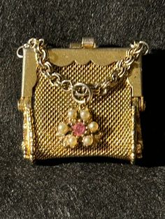 an old gold purse with pearls and a pink stone on it's clasps