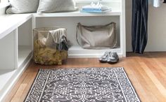 a white shelf filled with lots of items next to a rug and window sill