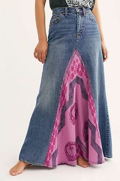 a woman in a black shirt is wearing a long skirt with pink and blue designs