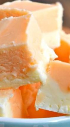 several pieces of cake sitting on top of each other in a blue bowl next to oranges