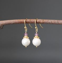 "Lustrous and opalescent white Akoya pearls are wire wrapped with balled gold pins and topped with gold caps and faceted Pink Quartz stones. These dangle from gold balled earwires. These classic pearl earrings are a wonderful addition to any jewelry wardrobe and are perfect to give as bridal gifts.  Multiple pairs can be ordered. A matching pendant is also available.  Want these in a different color?  Please send a message! Pink Quartz stones: 3mm Akoya pearls: 9mm Total length of earrings: 1 1/ White Pearl Crystal Earrings For Pierced Ears, White Pearl Crystal Earrings, White Pearl Earrings With Ear Wire, White Wire Wrapped Pearl Earrings For Gift, Delicate White Wire Wrapped Pearl Earrings, Elegant White Crystal Earrings With Ear Wire, White Crystal Pearl Drop Earrings As Gift, White Wire Wrapped Round Pearl Earrings, Elegant Wire Wrapped Crystal Earrings