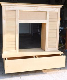 an unfinished fireplace built into the side of a garage with storage drawers on each side