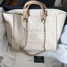 Chanel Canvas Pearl Large Deauville Tote Please Zoom In On Exterior Photos To See Normal Slight Rubbing And Pulling. Color: Ecru Beige Size: Large This Is An Authentic Chanel Canvas Pearl Large Deauville Tote. The Tote Comes With The Original Box, Authenticity Card And Original Dust Bag. Includes The Original Cleaning Kit And Cloth That Have Never Been Opened Or Used. Purchased 1/15/2021 At Chanel In Mclean, Va. This Highly Sought After Collectible Is Crafted Of Fine Canvas In Light Beige With A Pearl Chanel Rue Cambon Paris Logo. It Features Rolled Leather Top Handles And Fabric Threaded Gold Chain Shoulder Straps. The Top Is Open To An Ecru Fabric Interior With Zipper And Patch Pock Chanel Mini Wallet, Luxury Tote Bag, Chanel Tote Bag, Best Designer Bags, Chanel Tote, Replica Designer Handbags, Chanel Purse, Clipuri Video, Dior Handbags