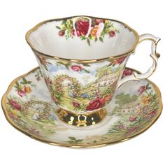 an antique tea cup and saucer with flowers on the bottom, gold trimming