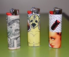 three lighters with pictures on them sitting on a table