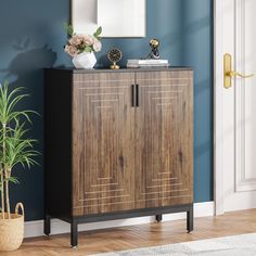 a wooden cabinet sitting on top of a hard wood floor next to a potted plant