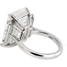 Discover the confluence of artistic legacy and contemporary creativity with this mesmerizing 15-carat Emerald Cut Diamond Engagement Ring. At the heart of this masterpiece is a breathtaking 15.30-carat emerald-cut diamond, certified by GIA, showcasing an I color grade and internally flawless (IF) clarity. This diamond is a true marvel; its large table and elongated facets create a dance of light that reveals an inner fire, often overshadowing the subtle hints of color within. The I color grade, Luxury Gia-certified Platinum Diamond Ring, Luxury Gia Certified Emerald Cut Diamond Ring, Luxury Gia Certified Diamond Engagement Ring, Emerald Cut Diamond Engagement Ring, Emerald Cut Diamond Engagement, Yellow Jewelry, Emerald Cut Diamond, Ring Watch, Large Table