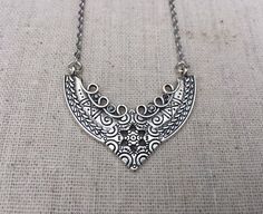 This is a stunning and unique boho pendant necklace.  It has incredible detail and design.  There are little Smokey crystal accents that really make the pendant stand out.  Dress it up or down, it is sure to give your look instant style.The pendant measures 1” long by 2” wide and is made from allergy free plated silver.  The pendant hangs from a simple 18”, including the extender, stainless steel necklace chain with a lobster clasp.I have matching earrings in my shop, if you would like the whole Snow Earrings, Boho Pendant Necklace, Snowflake Jewelry, Boho Pendant, Bohemian Necklace, Unique Jewelry Designs, Out Dress, Allergy Free, Steel Necklace