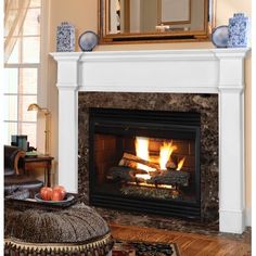 a fireplace with a mirror above it and some fruit on the table next to it