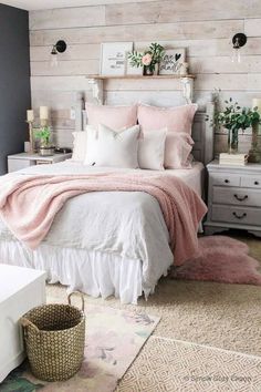 a bedroom decorated in pink and white with wood planks on the walls, bedding, rugs and pillows