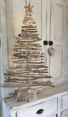 a christmas tree made out of branches on top of a dresser