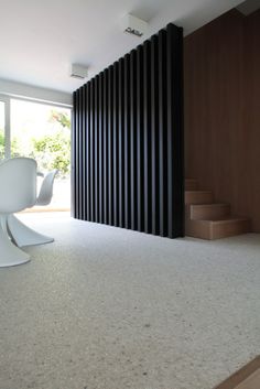 an empty room with black and white stripes on the wall next to some stairs in front of a large window