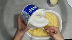 a person is pouring milk into a bowl of scrambled eggs with yogurt on the side