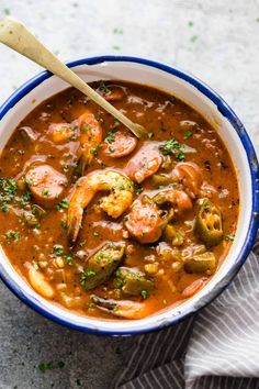 a blue and white bowl filled with shrimp stew