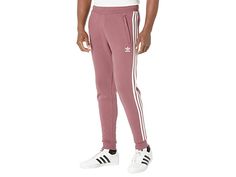 adidas Originals 3-Stripes Pants - Men's Casual Pants : Quiet Crimson : Stay on track with the adidas Originals 3-Stripes Pants. Part of the Adicolor Collection. Regular fit joggers with a tapered leg for modernized appeal. Soft French terry fabrication delivers all-day comfort. Elastic waistband with interior drawstring. Side hand pockets. Trefoil logo at left hip. Signature 3-Stripes detail featured at sides. Ribbed cuffs. Solid Colorways: 100% cotton; Heathered Colorways: 77% cotton, 23% poly Relaxed Fit Sportswear Activewear With Three Stripes, Cotton Activewear With Three Stripes In Relaxed Fit, Adidas Relaxed Fit Athleisure Joggers, Branded Relaxed Fit Sportswear Joggers, Sporty Relaxed Fit Sweatpants With Three Stripes, Spring Streetwear Joggers With Three Stripes Branding, Relaxed Fit Three Stripes Sweatpants For Jogging, Cotton Sweatpants With Three Stripes For Jogging, Adidas Sweatpants For Spring Streetwear