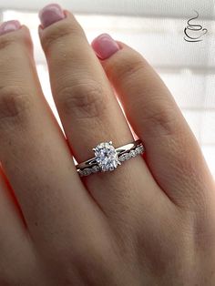 a woman's hand with a diamond ring on top of her finger and an engagement band