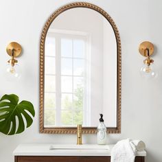 a bathroom vanity with a mirror, vase and towel on the counter next to it