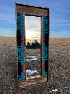 a mirror sitting on top of a dry grass field