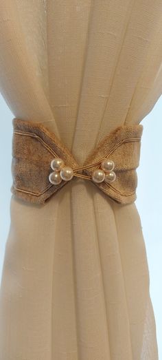 the back of a dress with pearls on it's belt and buttons at the waist