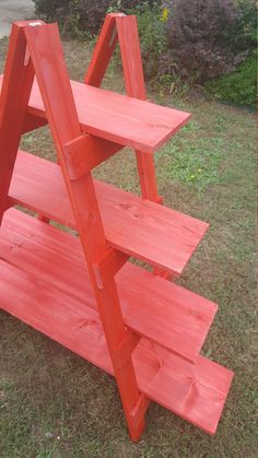 a red wooden shelf sitting in the grass