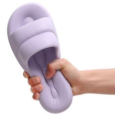 a hand holding an object in the shape of a slipper on a white background