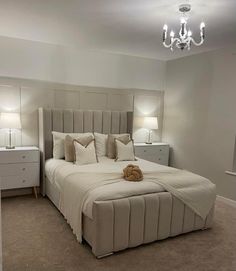 a bedroom with a bed, nightstands and two lamps on either side of the bed