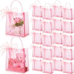 pink gift bags with teddy bear and flowers in them, all tied up to each other