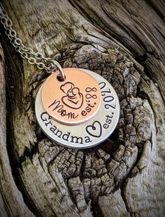 "Personalized hand stamped grandma necklace. Gift for grandma. Custom mothers day gift for grandma. Nana necklace. Memaw gift. First time grandma gift. Pregnancy announcment to mom. Custom pregnant announcement. Hand stamped and made to order. Made from a 5/8\" copper disc, stamped with a mama and baby stamp and stamped with the phrase, \"Mom est. (year of your choice),\" then a 7/8\" aluminum disc, stamped with the phrase, \"grandma est. (year of your choice).\" Stacked together and attached to Mother's Day Hand Stamped Necklace Gift, Hand Stamped Round Necklaces For Mother's Day, Hand Stamped Round Necklace For Mother's Day, Hand Stamped Jewelry For Birthday And Mother's Day, Hand-stamped Jewelry For Birthday And Mother's Day, Meaningful Hand Stamped Necklace For Mom, Hand Stamped Necklace For Mother's Day, Meaningful Stamped Necklace For Mother's Day, Hand Stamped Necklace For Father's Day