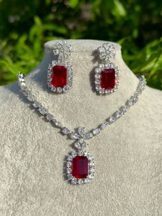 Handmade  Style: Necklace and Earrings Set Material: Platinum Plated, Lab Simulated Ruby and White Sapphire Stones Imported Please Note: This necklace and earrings are sold as a set. Item Number: 7078R Luxury Red Dangle Jewelry, Red Crystal Jewelry With Matching Earrings, Fine Ruby Drop Earrings Jewelry, Elegant Ruby Jewelry Sets With Matching Earrings, Fine Ruby Drop Earrings, Formal Pendant Jewelry With Stones, Sterling Silver Bridal Necklace With Matching Earrings, Sterling Silver Bridal Necklace With Matching Earrings Gift, Cubic Zirconia Jewelry Sets With Stones As A Gift