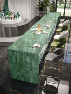 a long table with green marble on it in a room filled with bottles and chairs