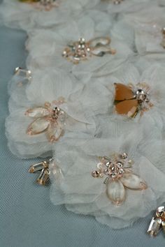 some white flowers and gold brooches on a table