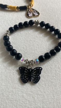 Introducing the ultimate accessory for all you dark and daring fashionistas out there - our black butterfly bead bracelet! With its goth-inspired, this piece is the perfect addition to any Halloween outfit or just an edgy everyday look.  Featuring intricate flower spacer beads and a breathtaking black butterfly charm, this beaded bracelet is sure to turn heads wherever you go.  Measuring 7 inches in width, it's the perfect fit for most wrists. So why wait? Add a touch of dark elegance to your wardrobe today with this new, edgy bracelet. Black Charm Bracelet, Edgy Black Beaded Jewelry, Adjustable Emo Style Bracelet As Gift, Adjustable Emo Style Bracelet For Gift, Black Edgy Bracelets As Gift, Adjustable Emo Style Bracelets, Alternative Style Black Bracelets As Gift, Alternative Style Black Bracelet Gift, Alternative Style Black Bracelet For Gift