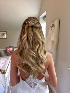 the back of a woman's head as she stands in front of a bed