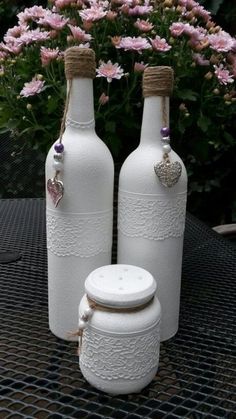 two white vases sitting on top of a table