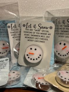 several snowman magnets are on display in plastic bags with tags attached to them