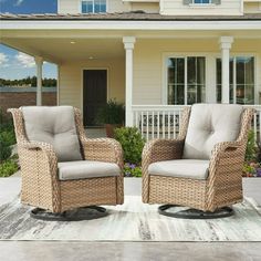 two wicker chairs sitting in front of a house