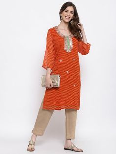 Georgette Kurti  , Summer Kurti  , Indian summer wear    , Orange kurta  ,    FREE  SHIPPING This is a  Summer Evening  Wear  Orange   Embellished   Kurta . The Main colors are  Orange ,  Yellow  and  Silver . The Front Yoke  is  beautifully embellished   in silver  color., with silver gota patti . The Kurta is lined with cotton on both front  and back . MATERIAL : Orange   and  Yellow   Striped  Tie Dye  Georgette  LINING : Matching  100% Cotton on front and back . MEASUREMENT: Chest - 42 Inches Length - 42 Inches Sleeve length - 18 Inches USE : You can either  Pair it with Denims  or  Capris  or  Trousers  or wear it as a dress  or  as an Indian Kurta . CARE INSTRUCTIONS : Gentle handwash in cold water using mild detergents . To maintain the vibrant colors , Please always dry in shade . Traditional Summer Tunic With Dupatta, Spring Orange Straight Kurta, Spring Festive Tunic With Printed Motifs, Orange Sets With Resham Embroidery For Spring, Orange Resham Embroidery Sets For Spring, Spring Orange Sets With Resham Embroidery, Spring Orange Resham Embroidery Sets, Summer Orange Kurta With Printed Motifs, Orange Kurta With Printed Motifs For Diwali